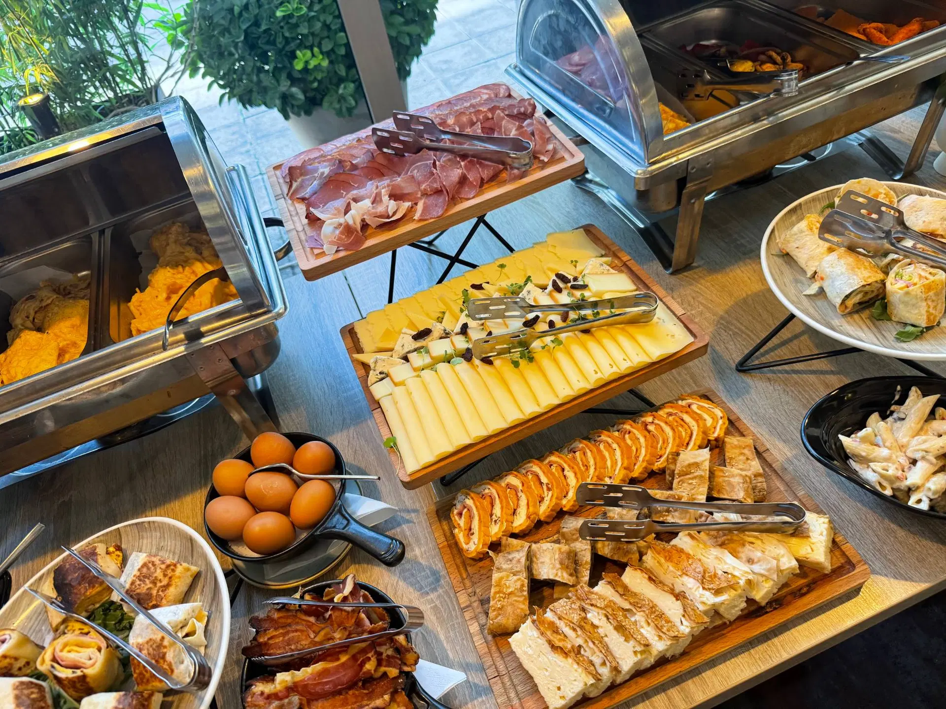 Pršuta, izbor sireva, rolati i domaće pite na brunch stolu
