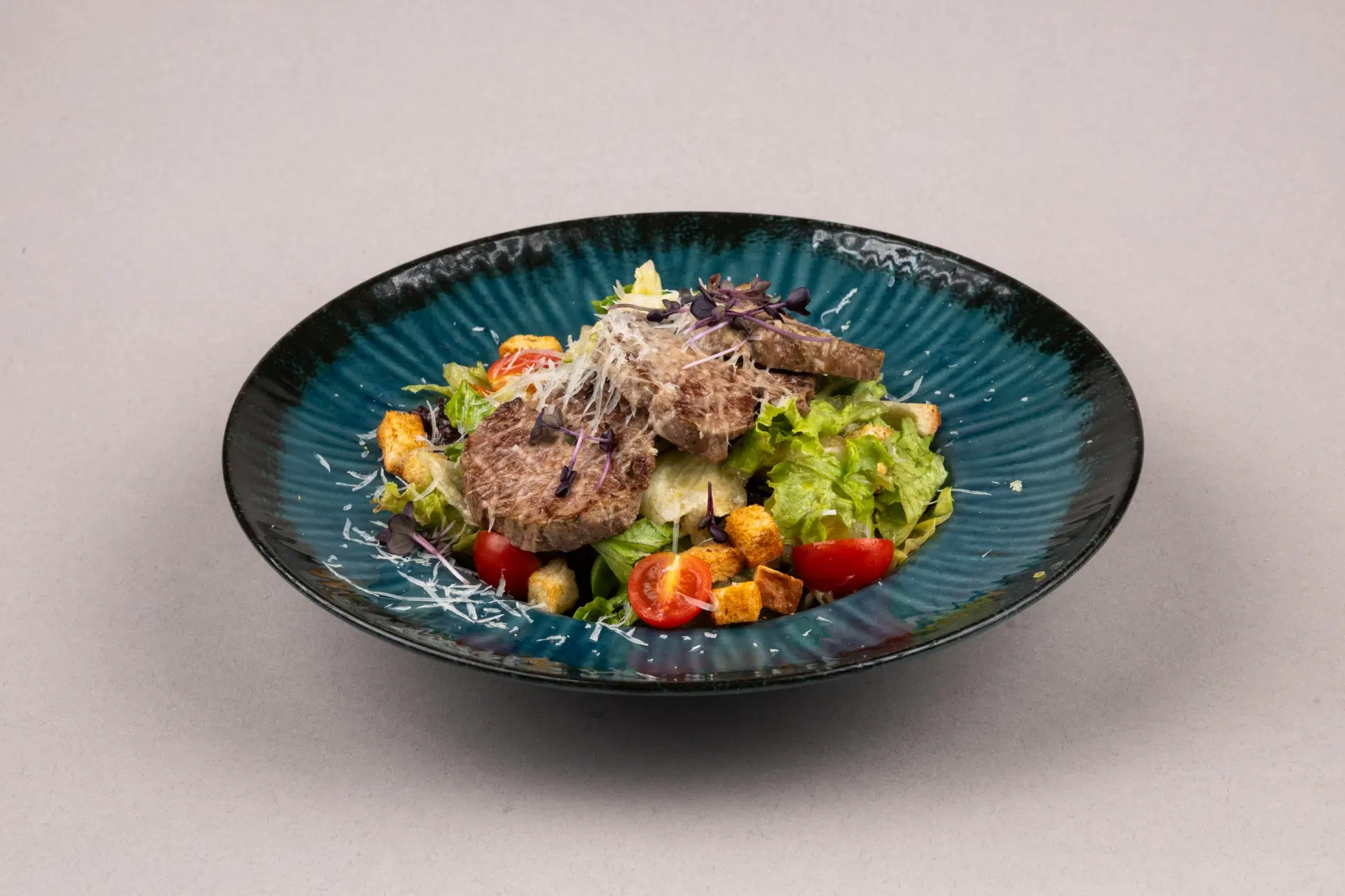 Obrok salata sa grilovanim mesom, krutonima, čeri paradajzom i parmezanom